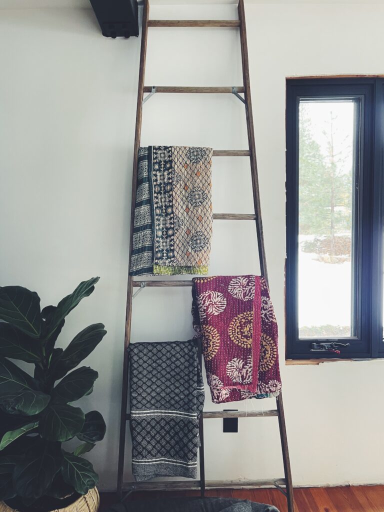 blankets hanging on rustic ladder