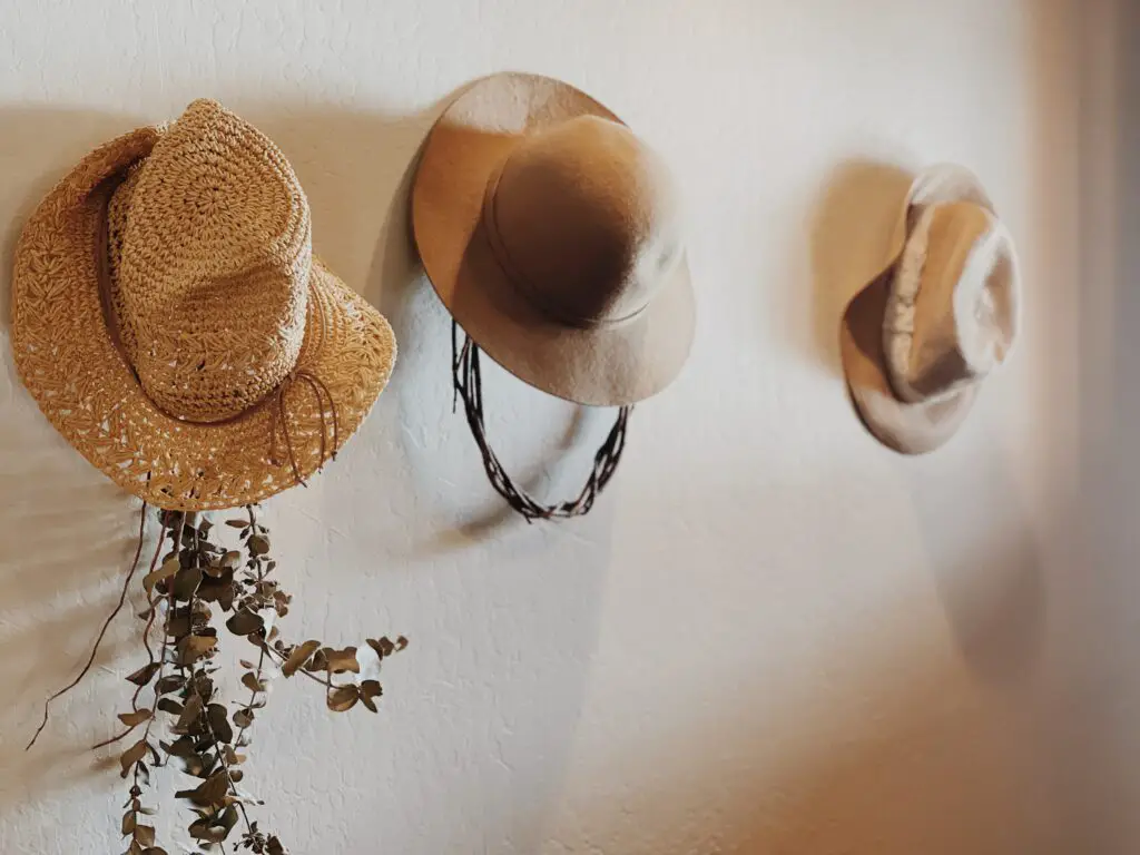 collection of straw hats hanging on wall