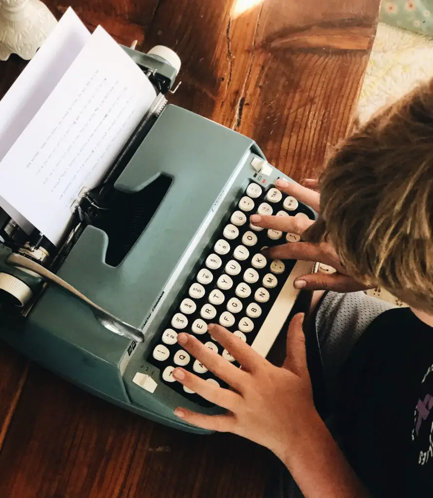 child typing on vintage typewriter