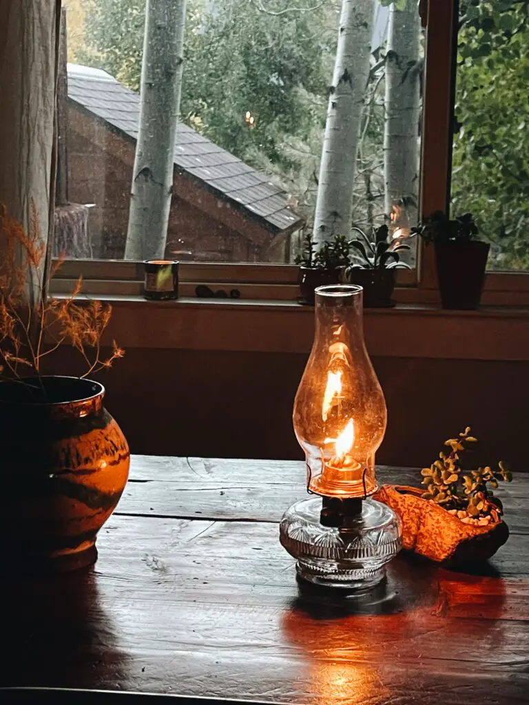 table with kerosene lamp near window