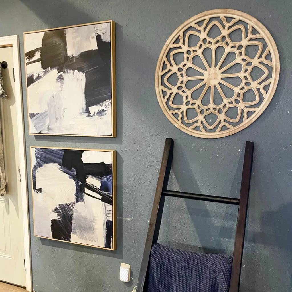 Blue artwork, white washed wood circle and blanket ladder