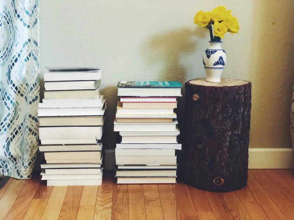 books stacked on floor and daffodils