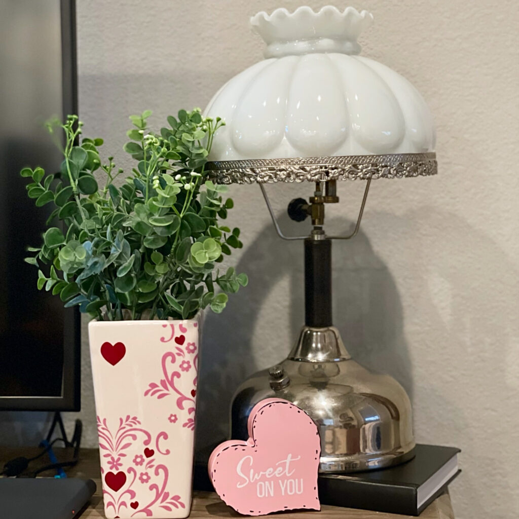 heart vase with spring greenery, oil lamp and heart shaped sign