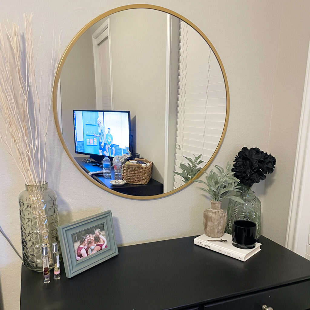Bedroom dresser and décor with round golden mirror