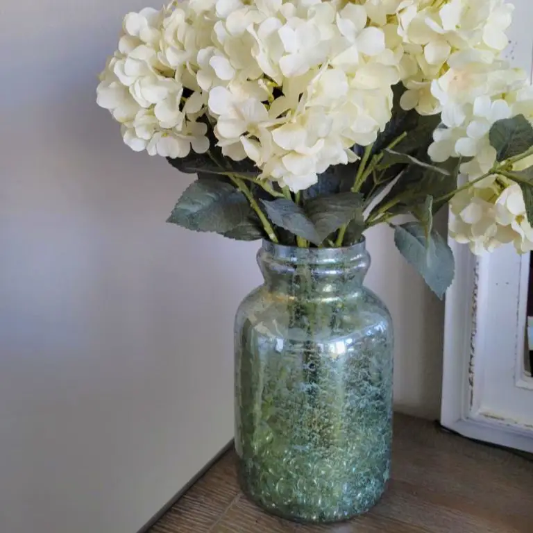 bluish green vase with cream florals