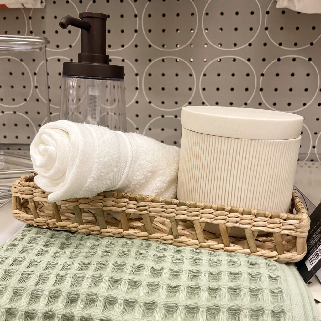 Wicker basket with neutral décor and a green towel.