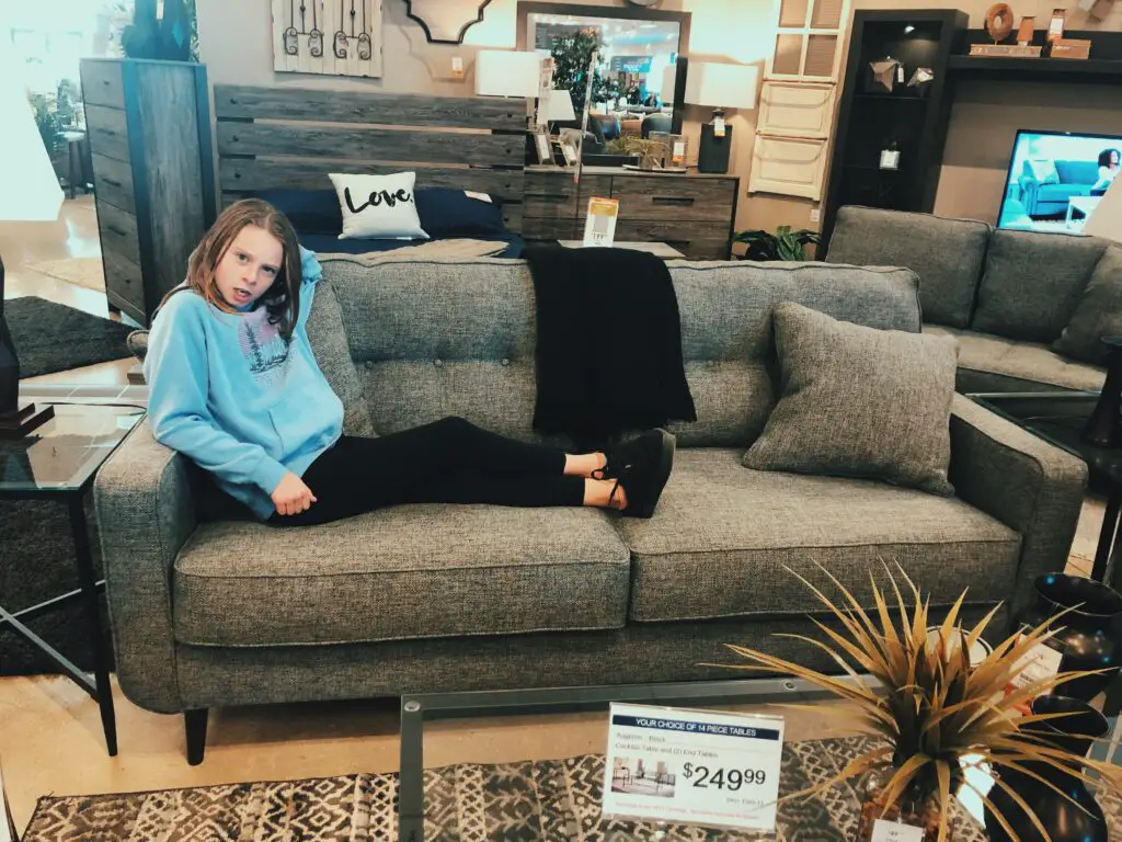 girl on couch at discount furniture store