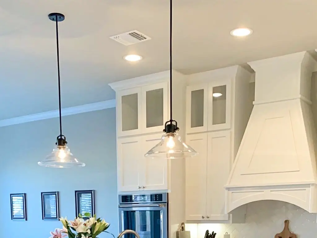 pendant lights with a industrial, rustic look in a white kitchen.