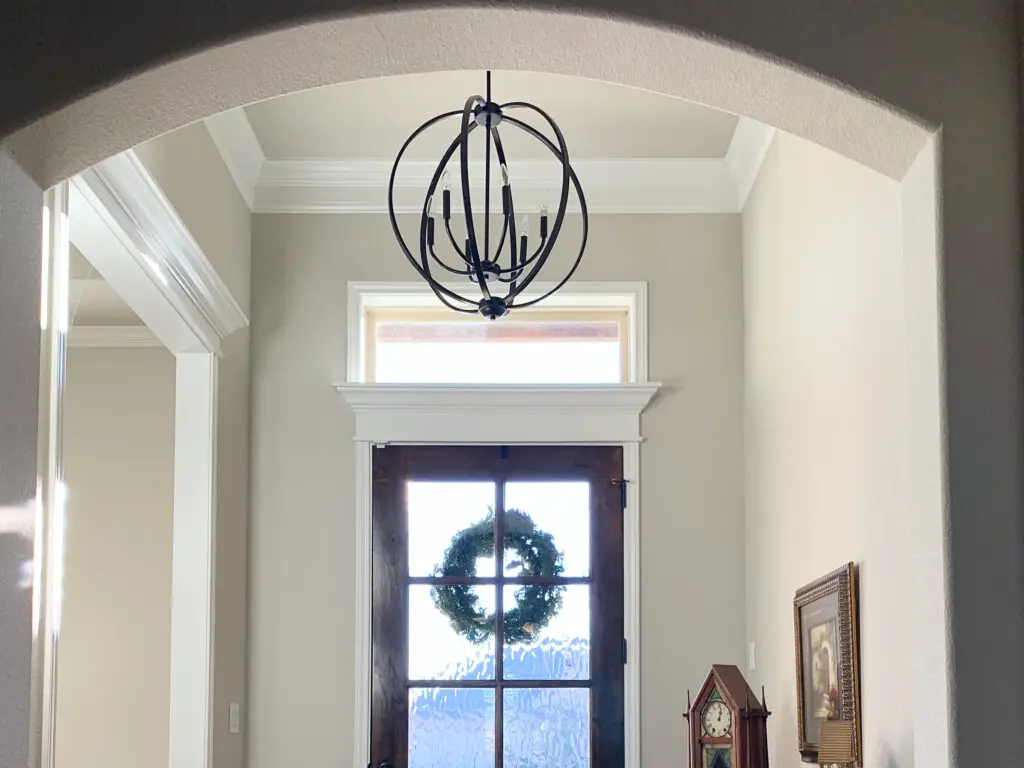 round, black, rustic chandelier in the foyer.