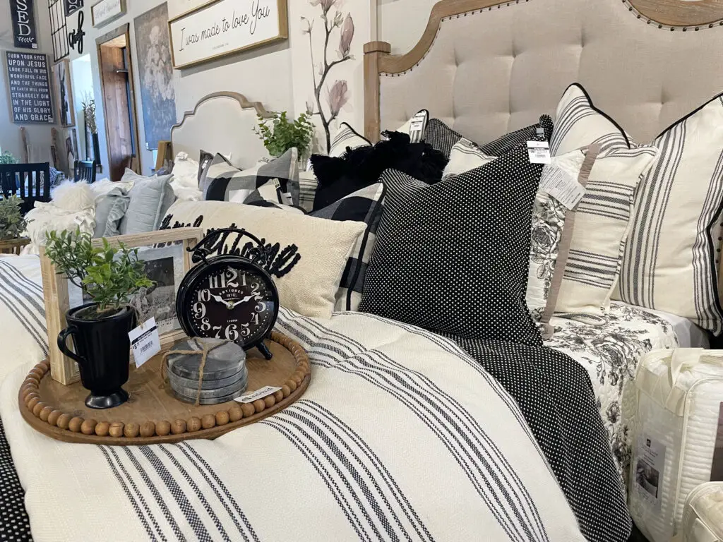 Black, white, and grey bedding with a mix of patterns like stripes, polka dots, and florals.