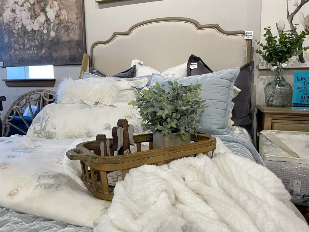 Blue, grey and white bedding with velvet, fur, and other textures