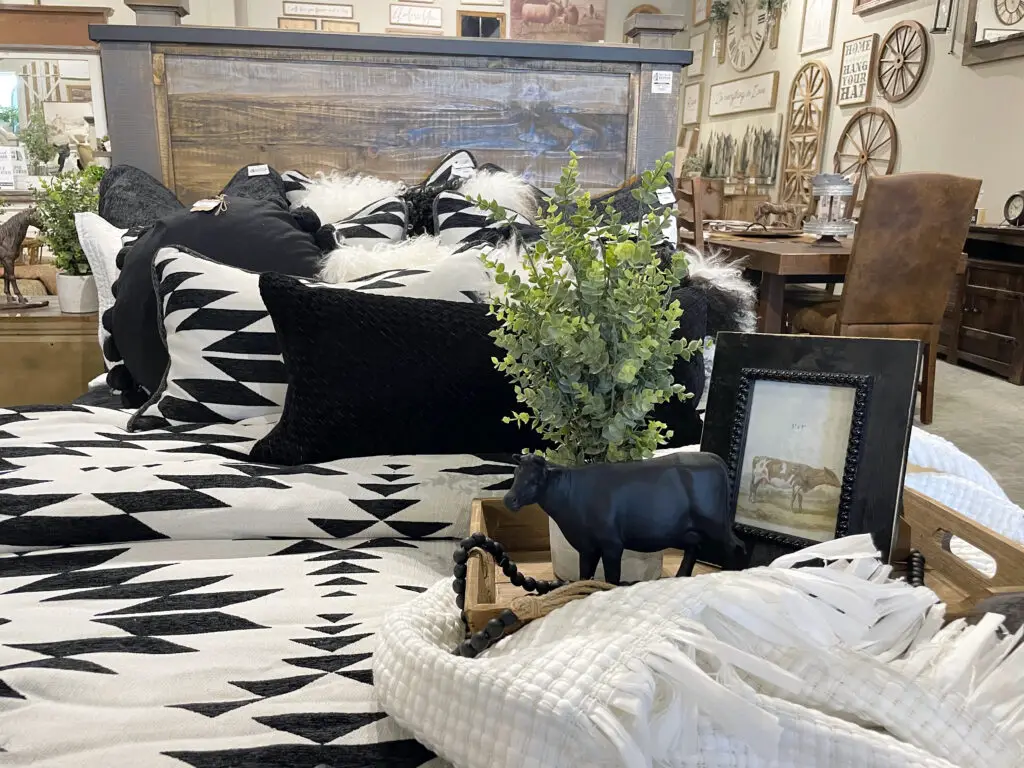 Black and white tribal patterned bedding with light wood tray & decorations.