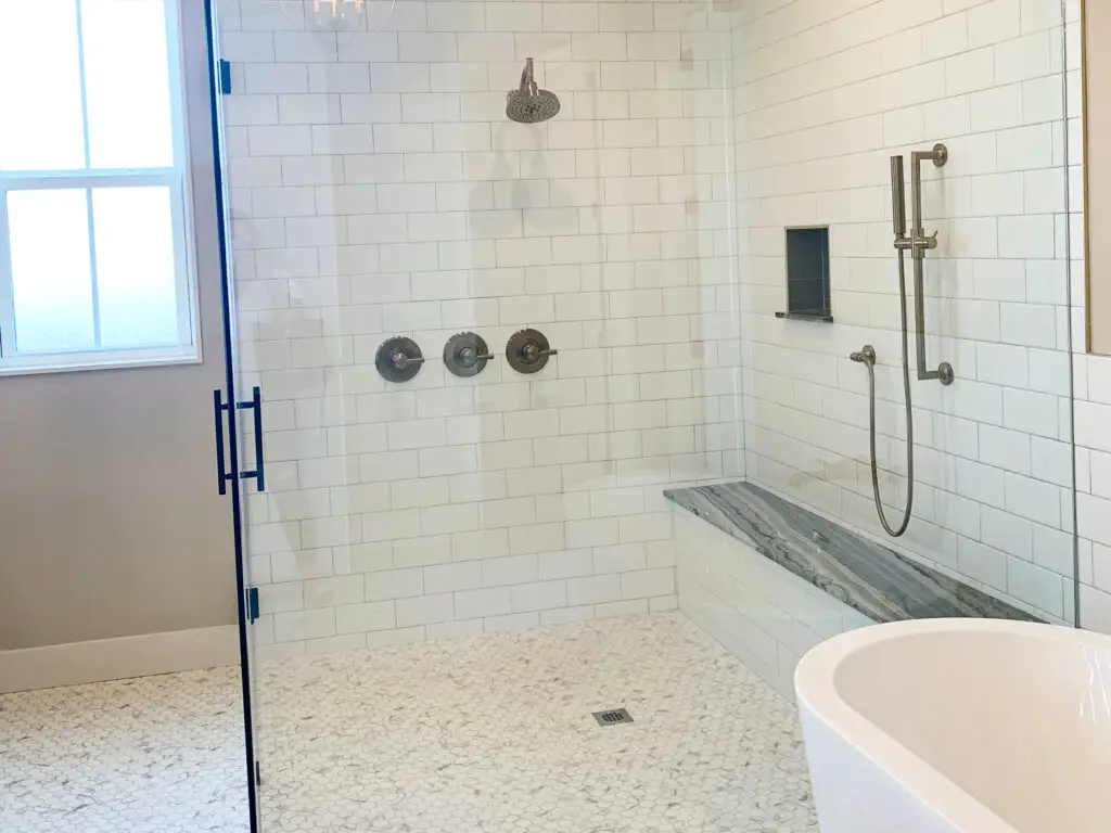 White and grey shower with champagne bronze accents