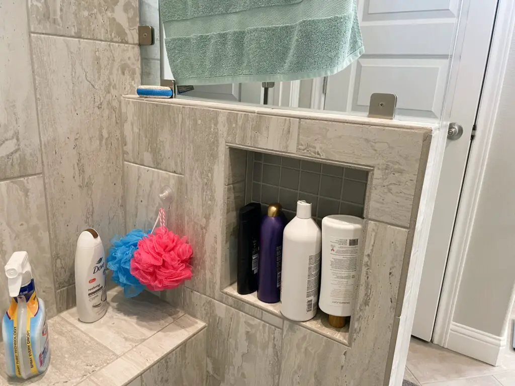 Hidden shower niche with bathroom necessities