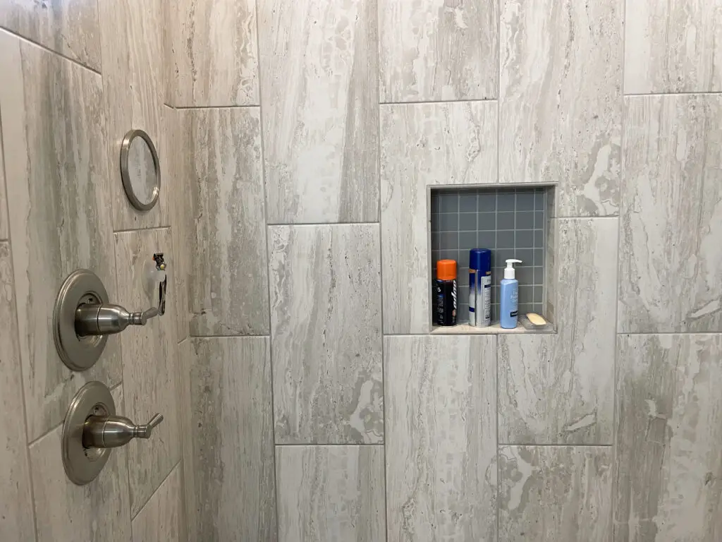 Shower niche with small grey tiles