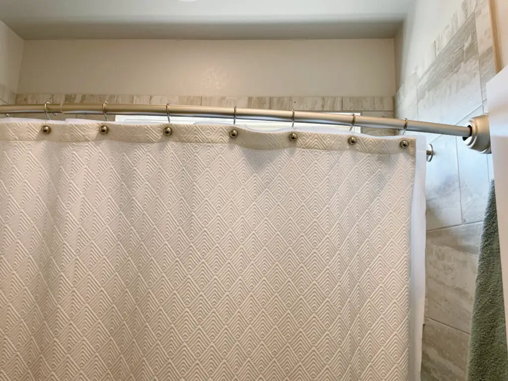 white textured shower curtain on rounded shower road