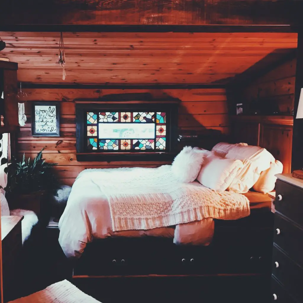 small bedroom with stained glass window