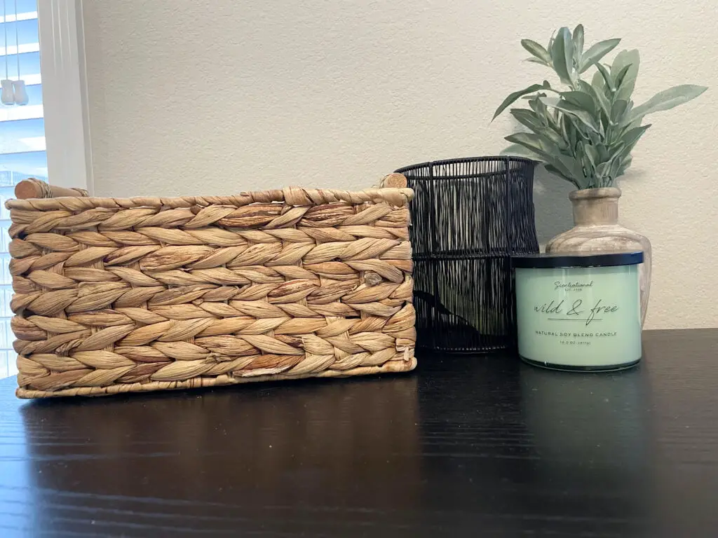 Wicker basket, wooden vase with. greens and black and green accents