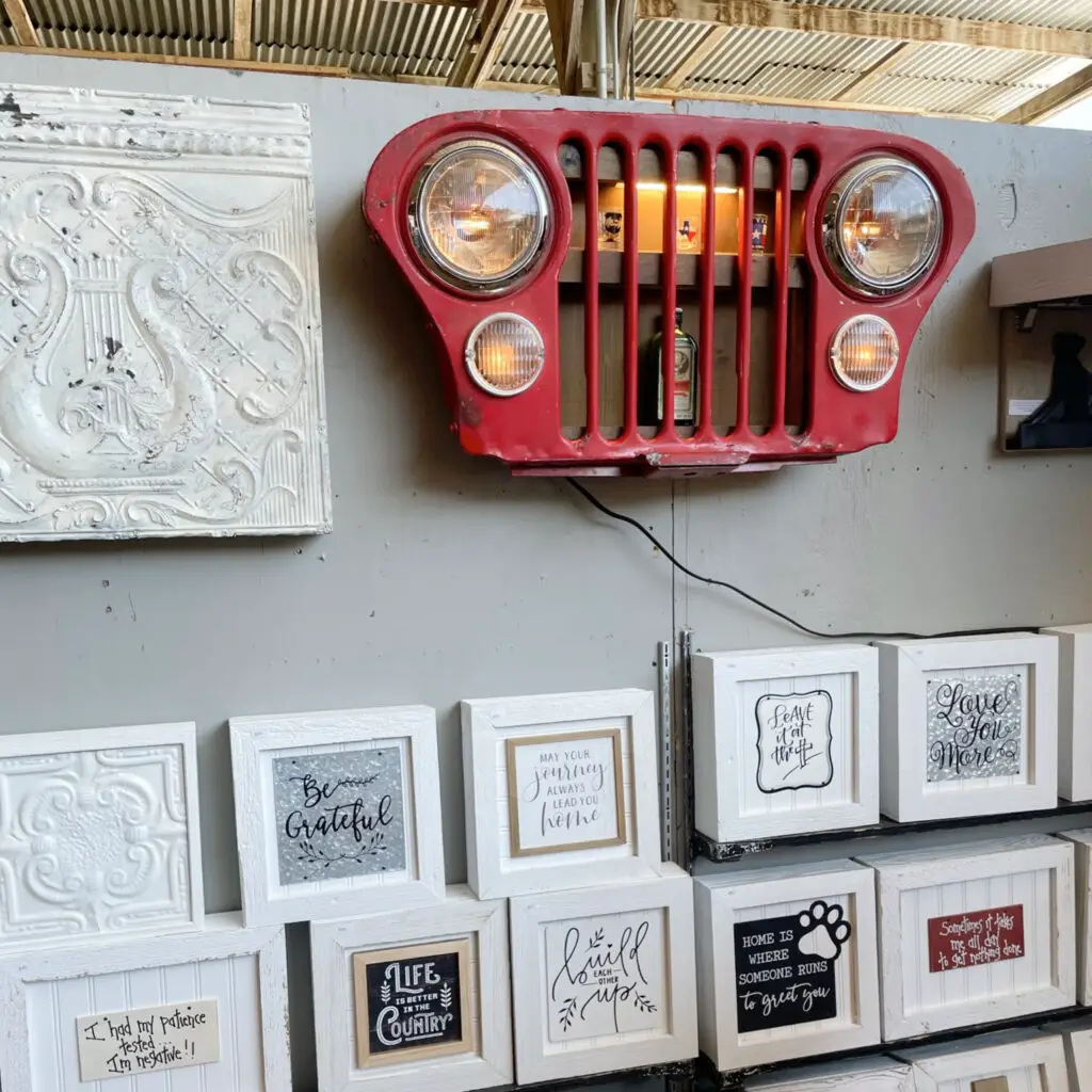 old, red car grill repurposed as large wall shelf art work.