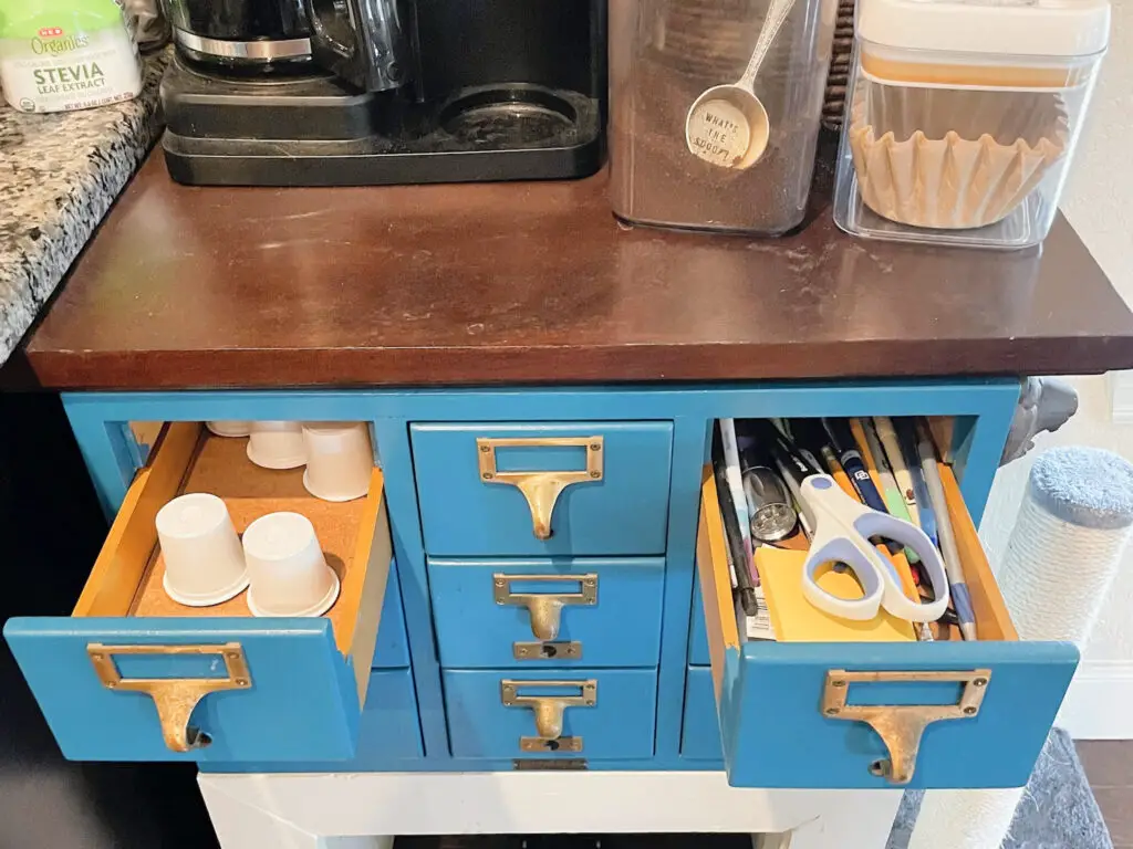 Library card drawers filled with Keurig cups, pens, pencils, and other miscellaneous items. 