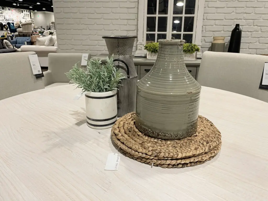 grey, white and black centerpiece on rounded dining room table