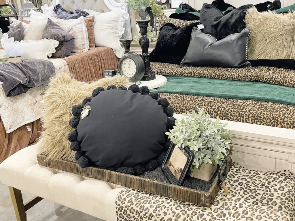 beige bench with golden legs adorned in cheetah print, black and neutral decor encased in a tray