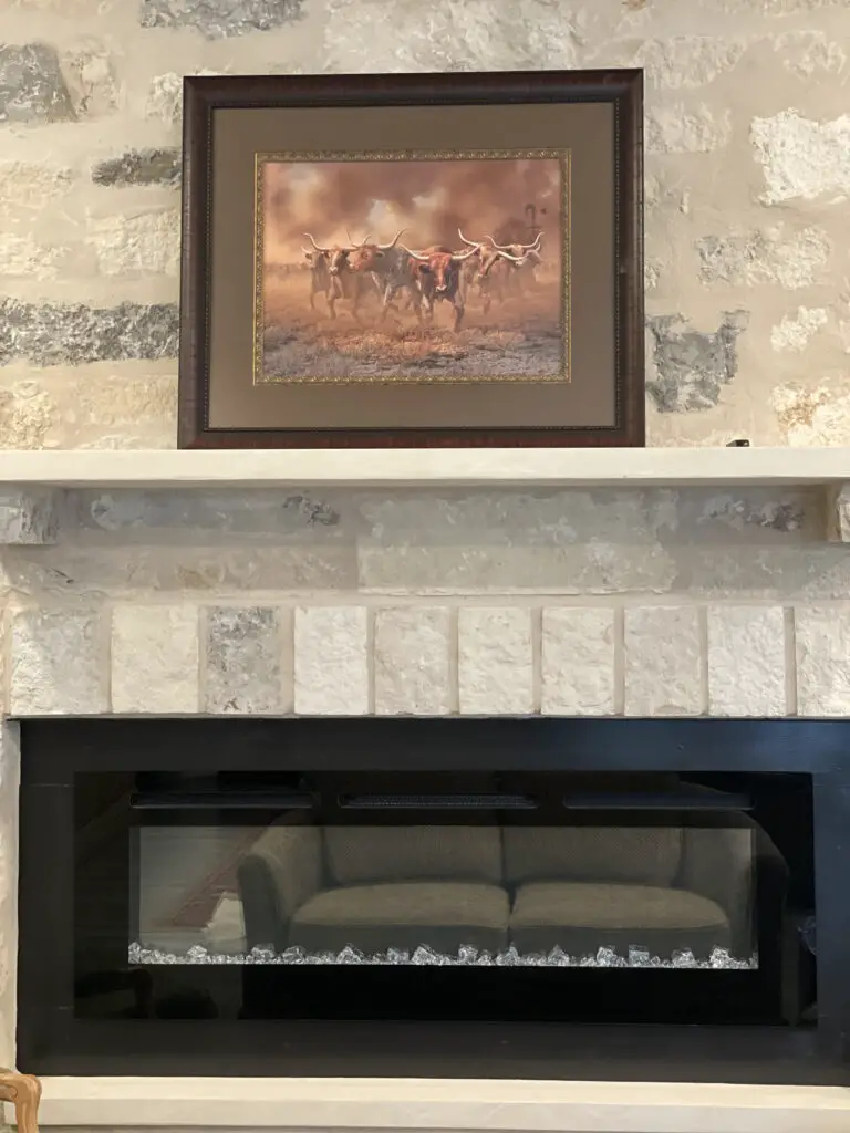 Light stone fireplace with framed longhorn decor