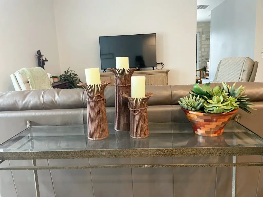 3 rustic metal candlesticks on a sofa table
