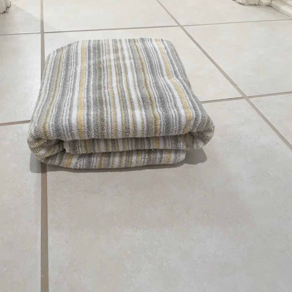 grey, white, and yellow striped towel folded neatly 
