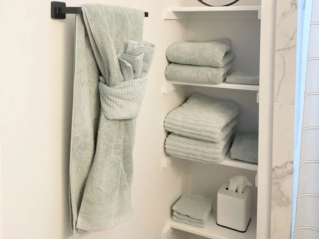 Light blue towels in a white bathroom with matte black hardware
