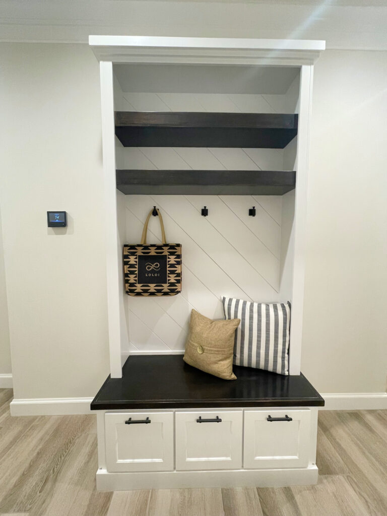 White mudroom bench with open shelving and pullout drawer storage