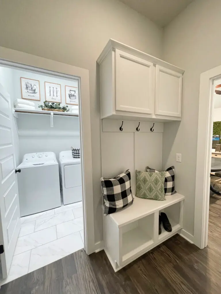 White mudroom bench next to laundry room