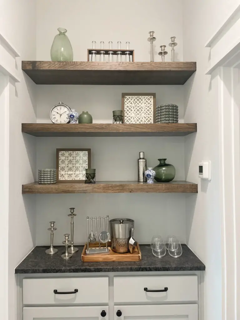 Cutout with open shelving and a bar tray with an ice box and bartending tools for home bar
