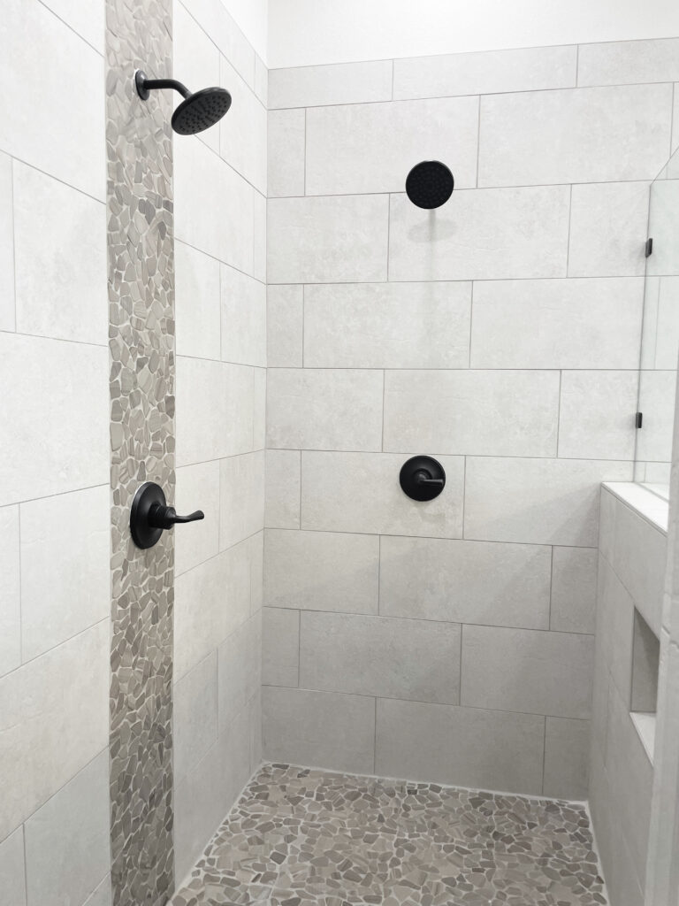grey shower tile with small vertical rock accent strip