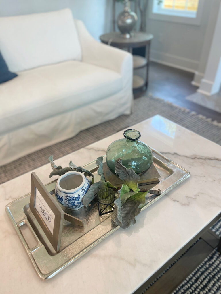 Silver tray with dainty green and blue vases on coffee table