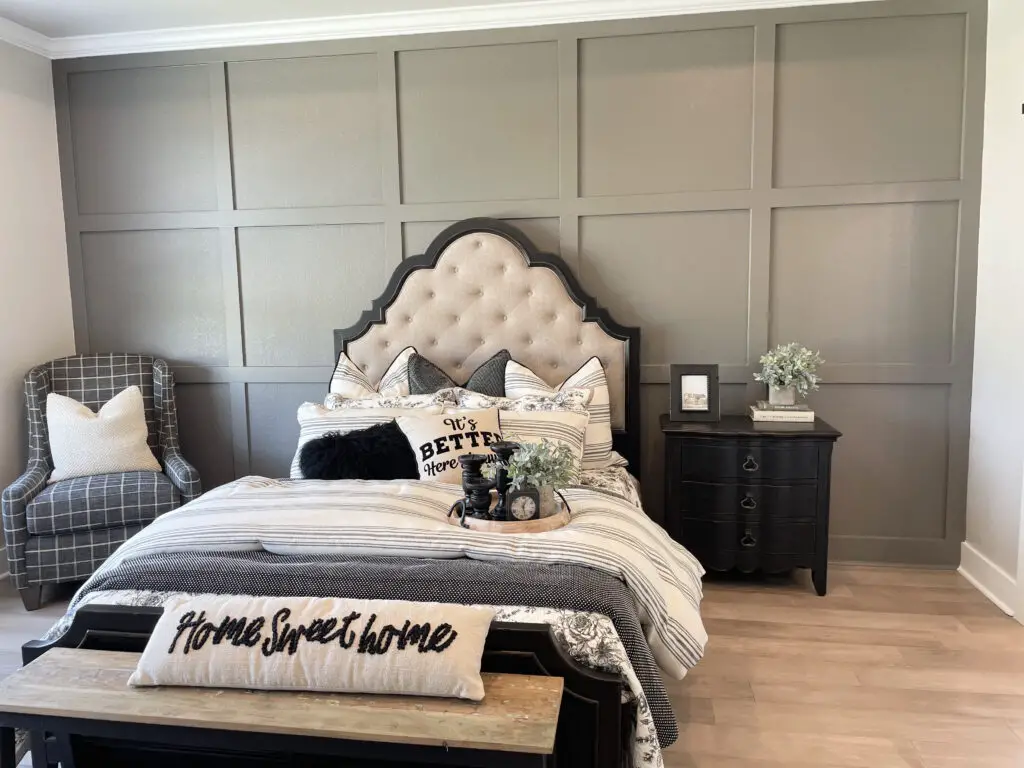Greige board & batten wall with black and white bedding and furniture