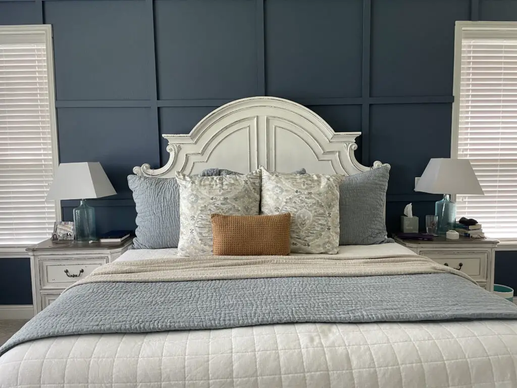 Dark blue board and batten wall with matching white bed and side tables