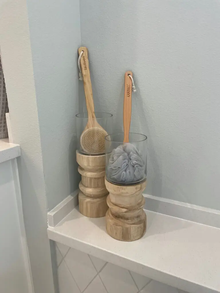 Large wooden candle holders filled with bath tub accessories