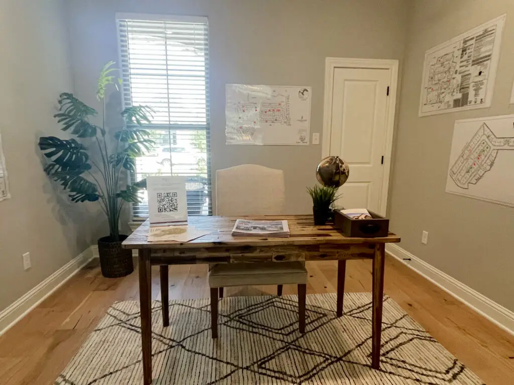 rustic wooden desk in the center of the room with a geometric textured rug beneath it