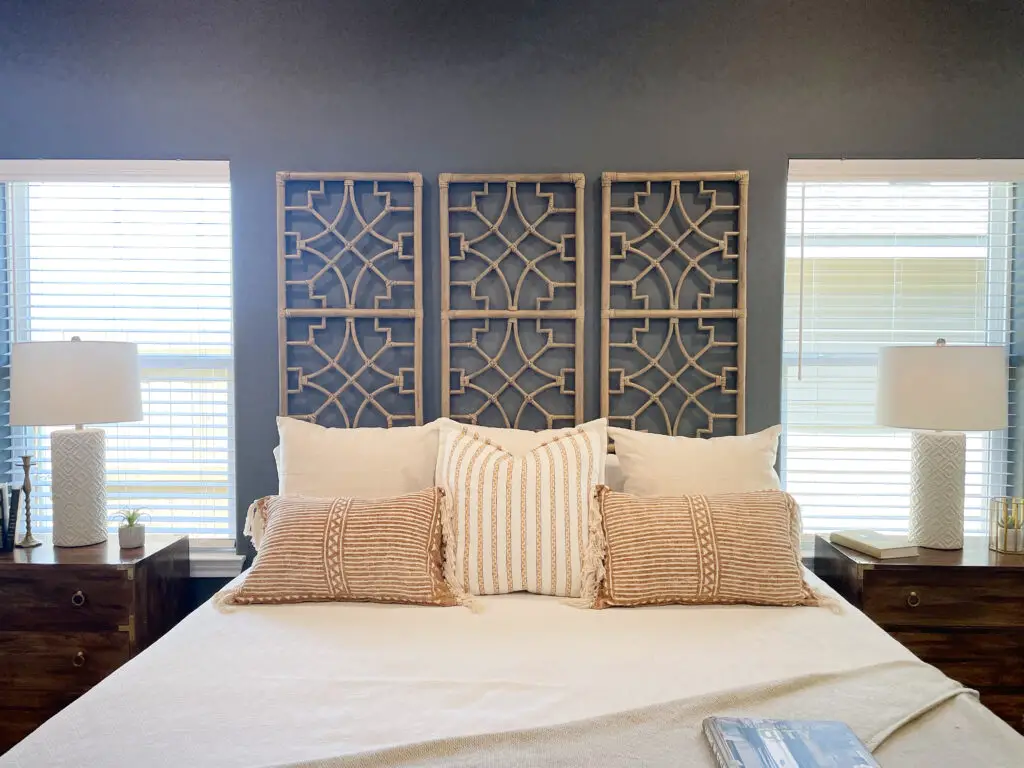 Feature wall hangings as headboard on a bohemian, modern farmhouse bedroom with terra-cotta, white and wood accents
