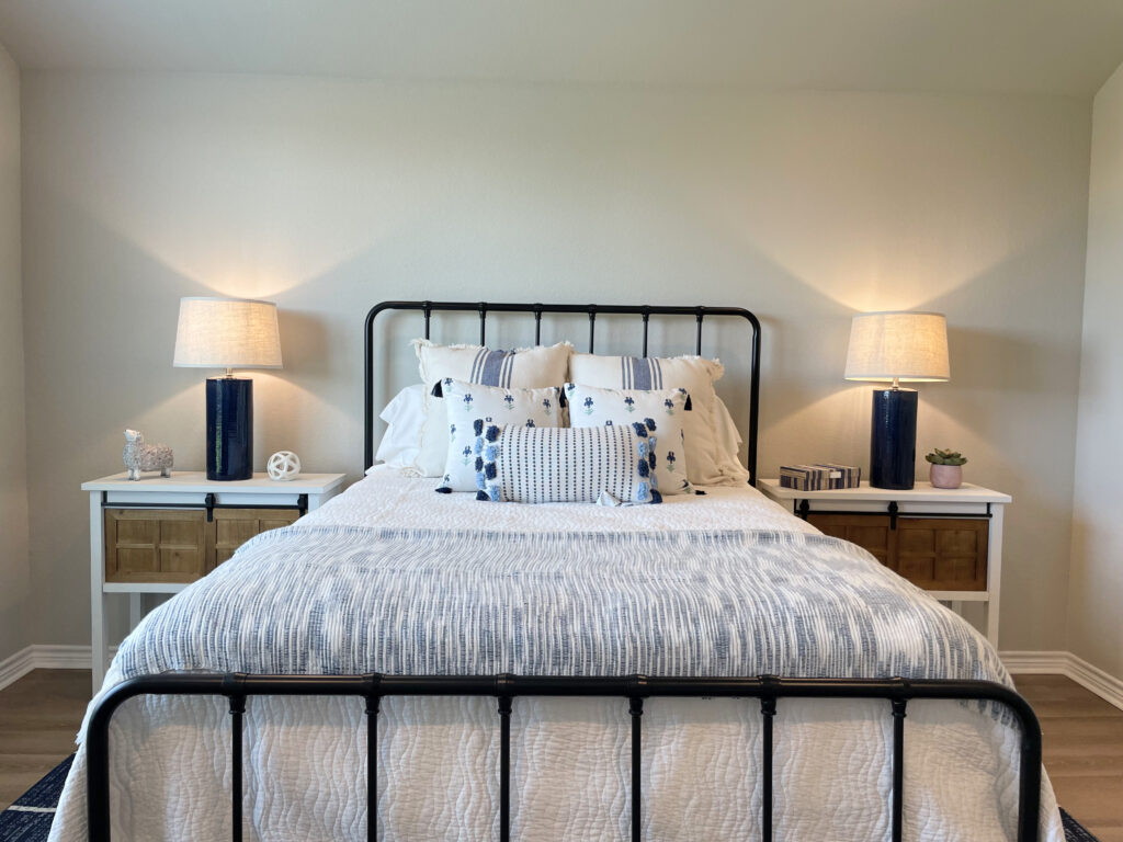 Iron piped headboard and footboard with blue and white bedding