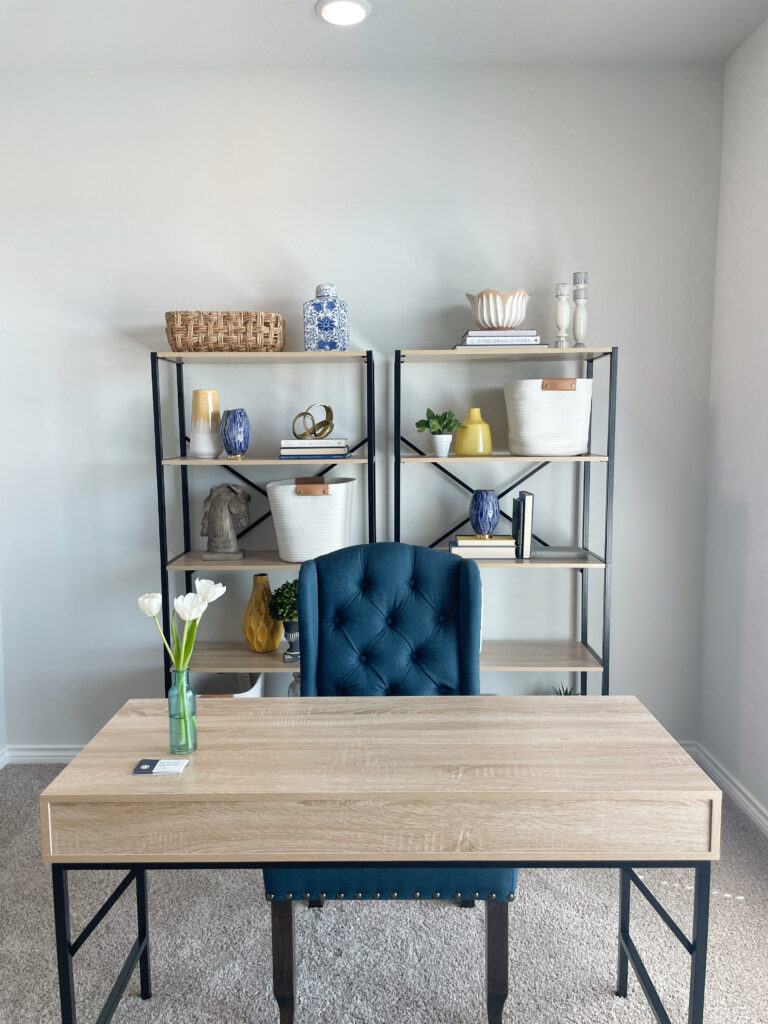 Yellow, white, and blue accents in an office on shelves and a wooden desk with a blue chair