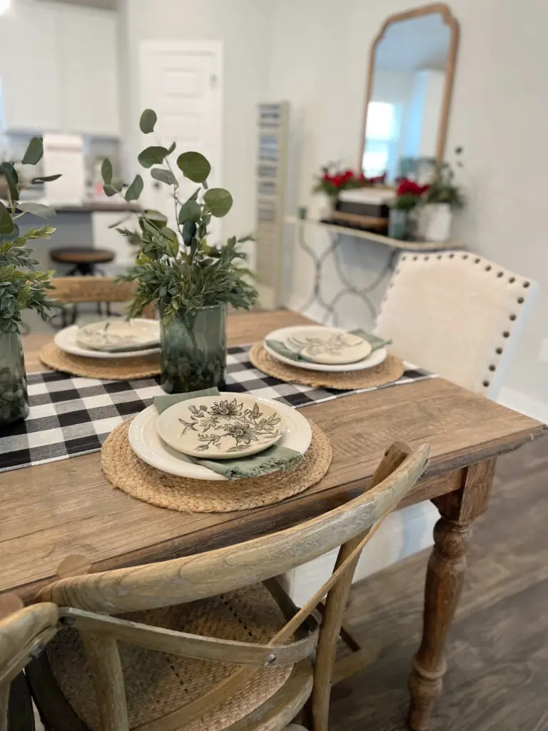 wooden farmhouse table, with black and white buffalo checked runner and green accents