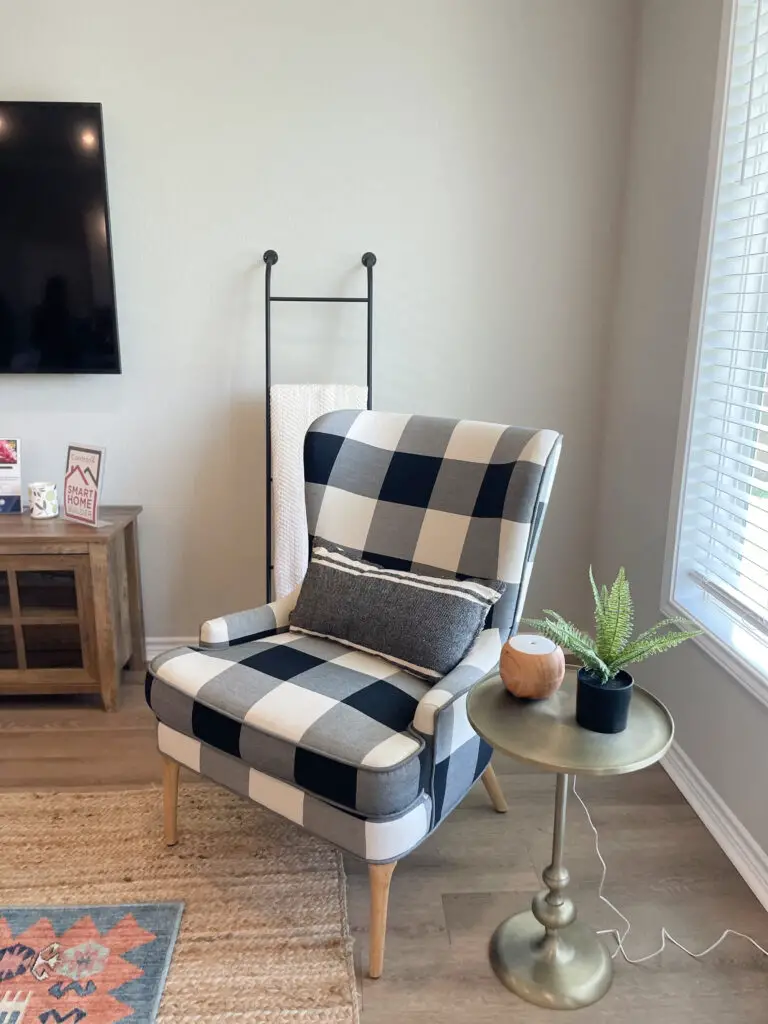 Black, metal blanket ladder behind accent chair in an eclectic living room
