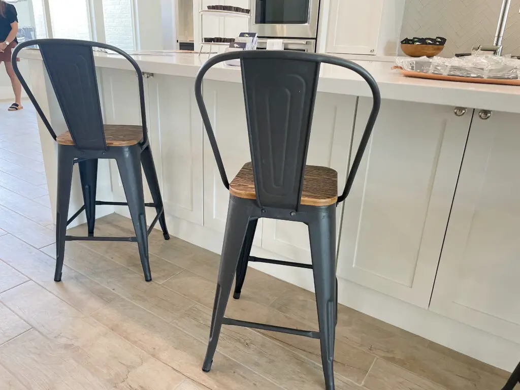 Metal backed stools with wood seats in white kitchen