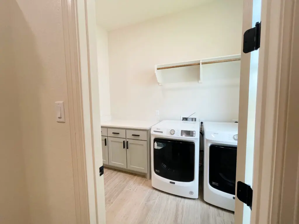 laundry room with grey cabinets and open shelving off of closet 