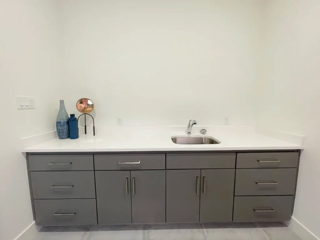 Built-in sink with white countertop and grey lower cabinetry