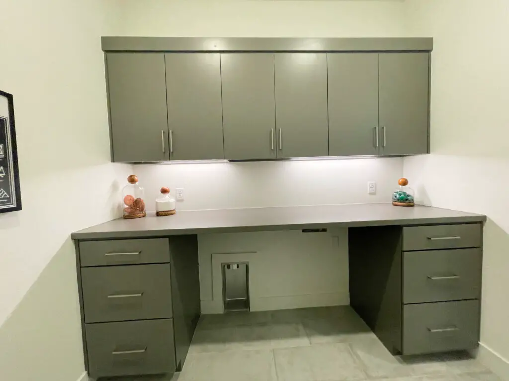 grey upper and lower cabinets in laundry room with glass and wood decorative accents