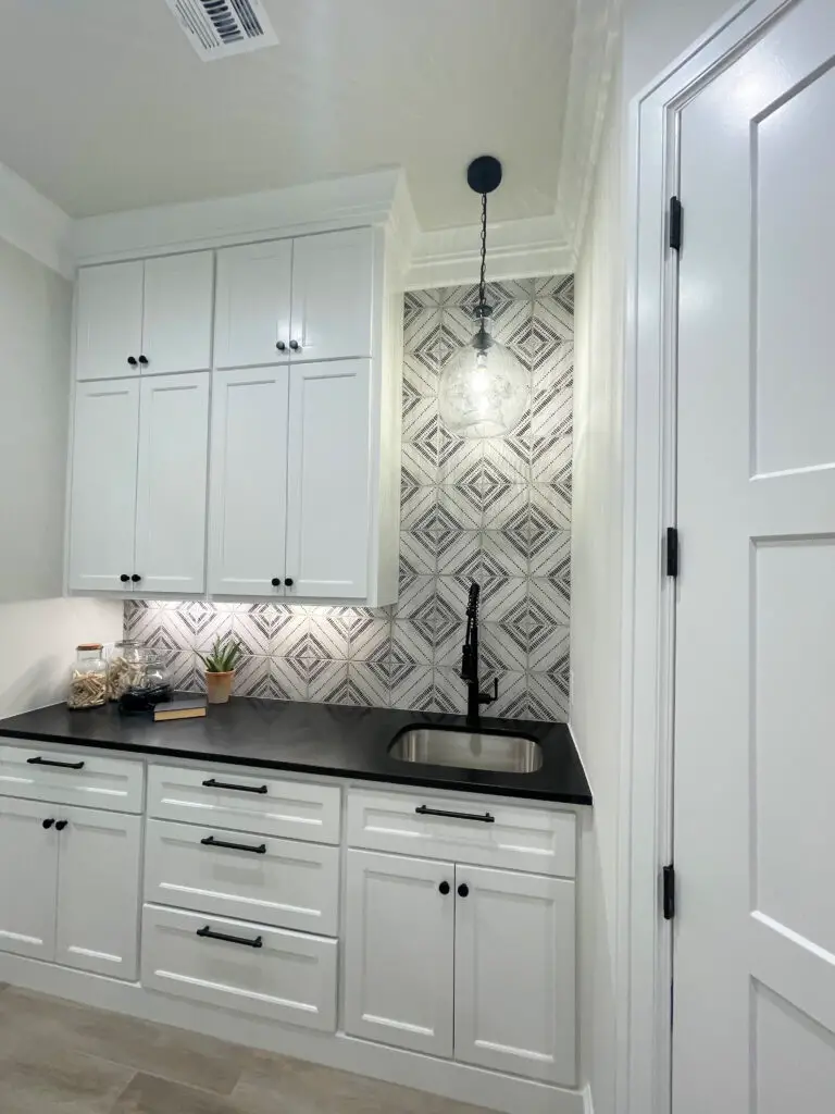 White upper and lower cabinets with a black counter & undercount lighting