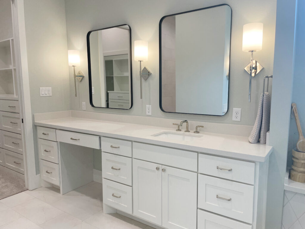white bathroom cabinets in dual vanity with pure white counter and silver hardware